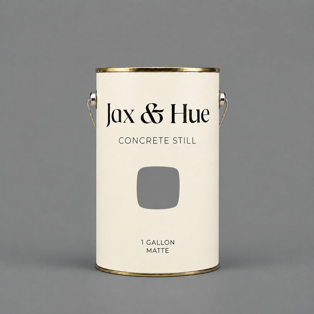 Jax & Hue Concrete Still neutral medium grey matte paint gallon on a matching grey background.