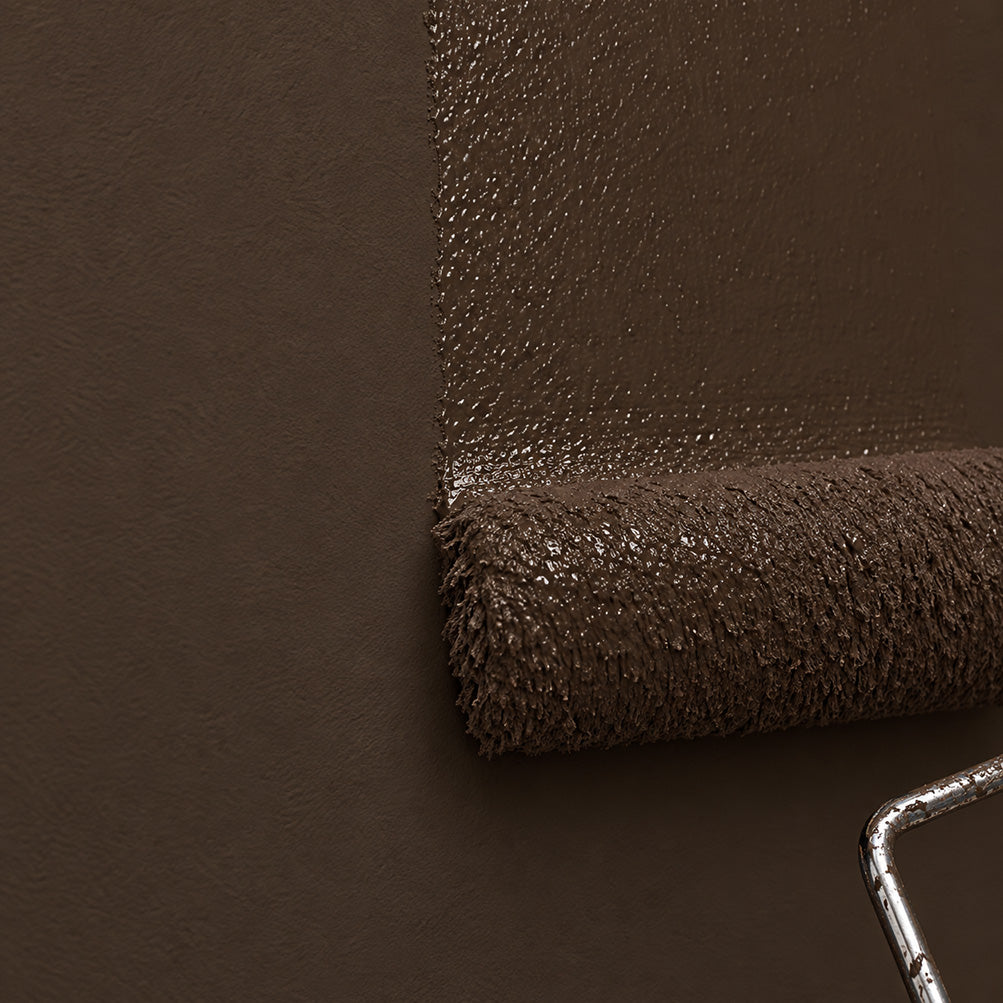 Paint roller applying Dark Kiln deep chocolate brown paint to a wall, showing the rich espresso-brown pigment beside the finished matte surface.