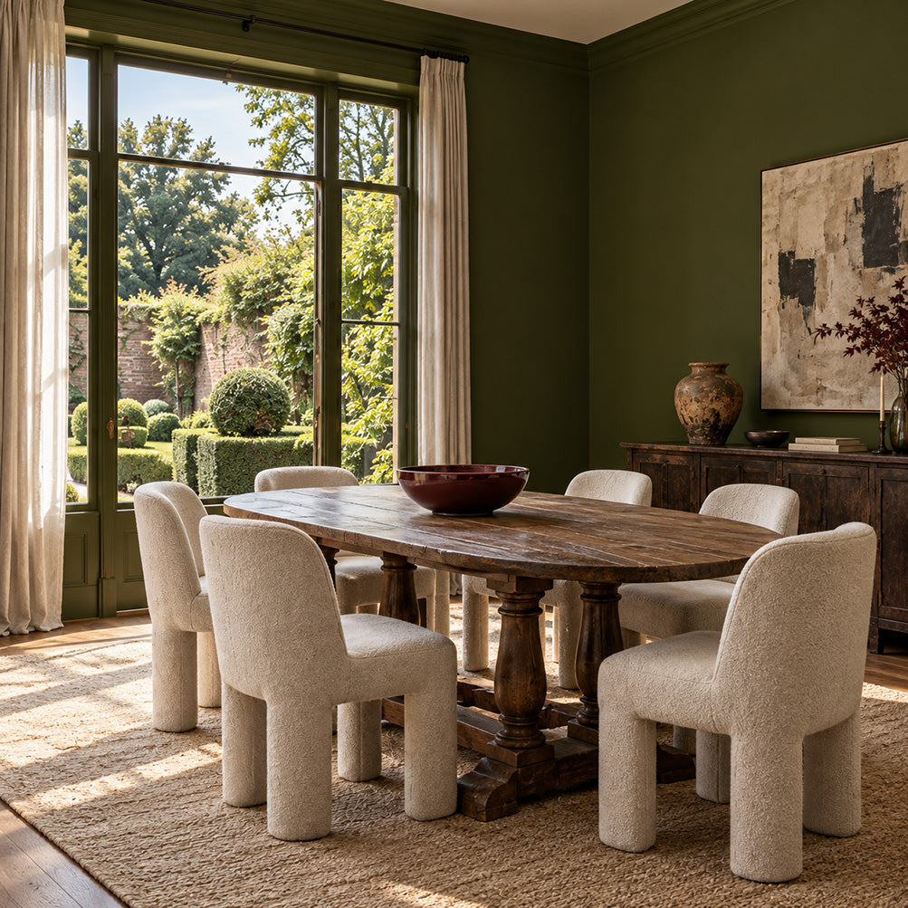 Garden Armory dark olive green dining room walls with an antique wood table, cream chairs, and garden views.