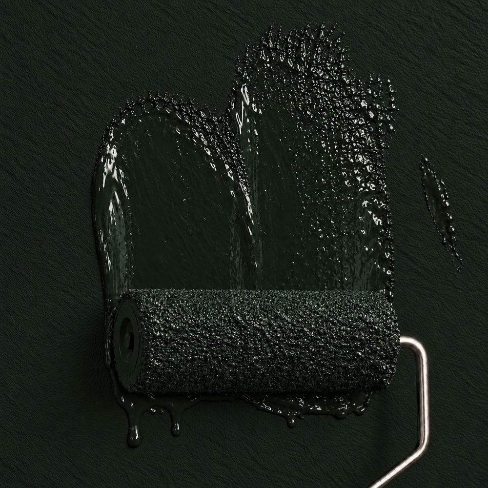 Paint roller coated in Juniper Hall deep muted green paint against a matching matte wall.