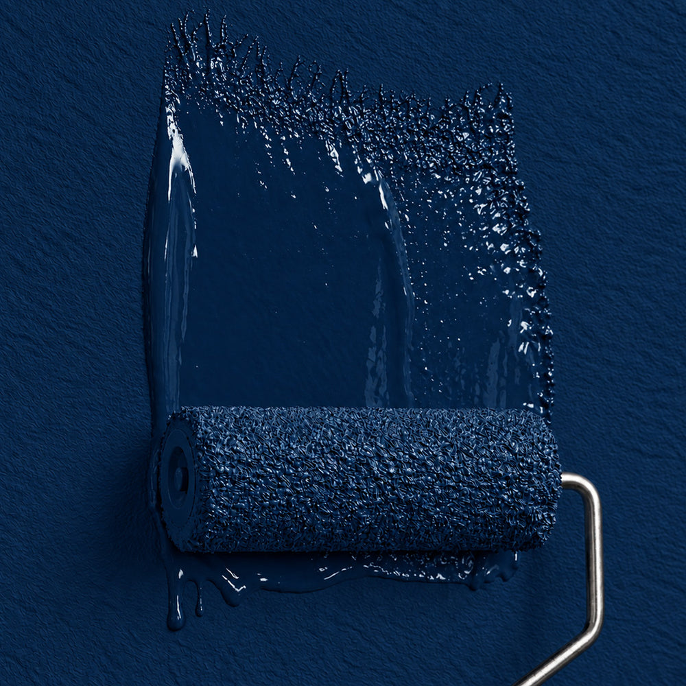 Paint roller applying Midnight Wharf saturated dark blue paint to a textured wall