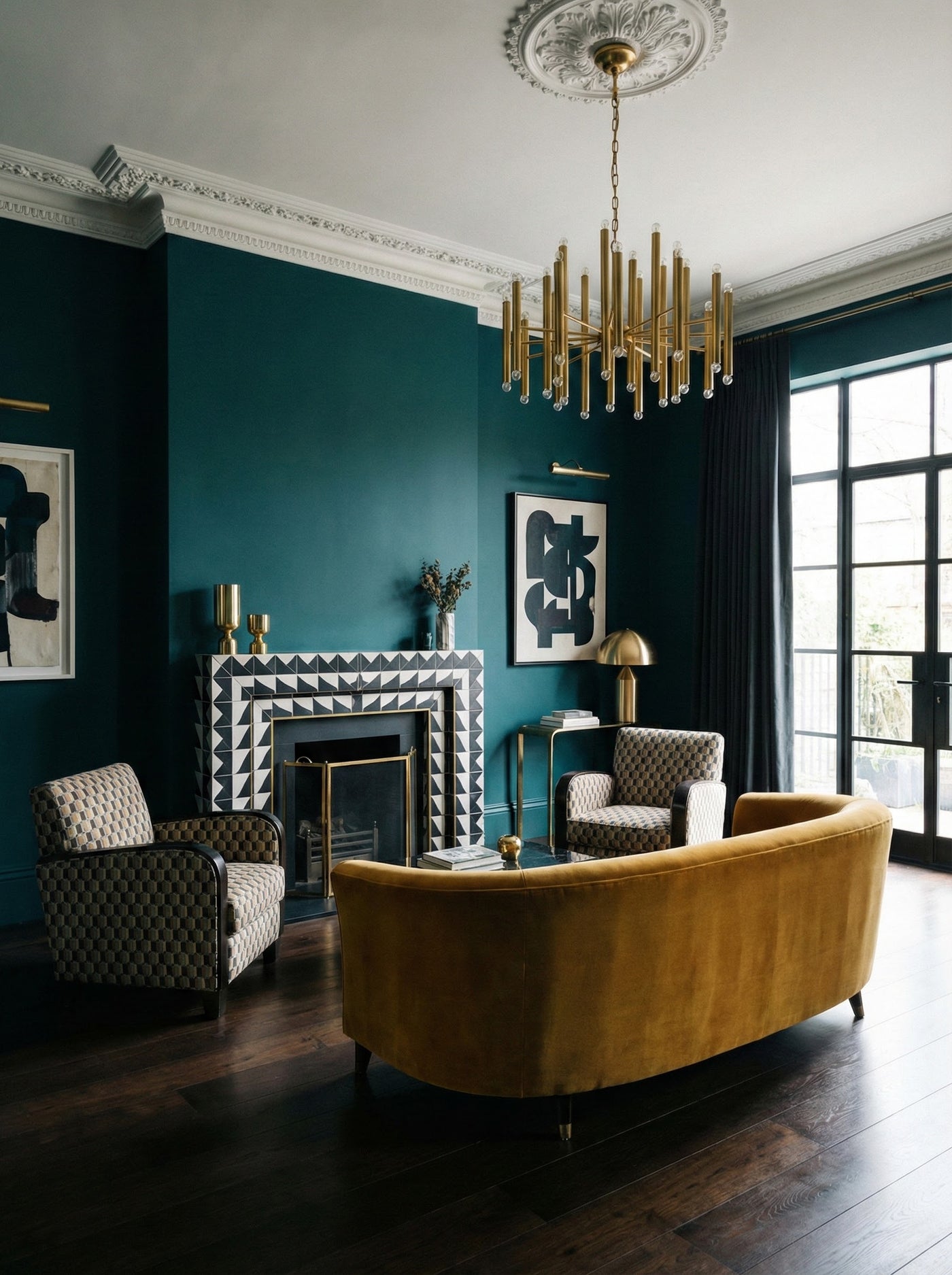 Luxurious living room with a gold chandelier, dark teal walls, and a yellow sofa.