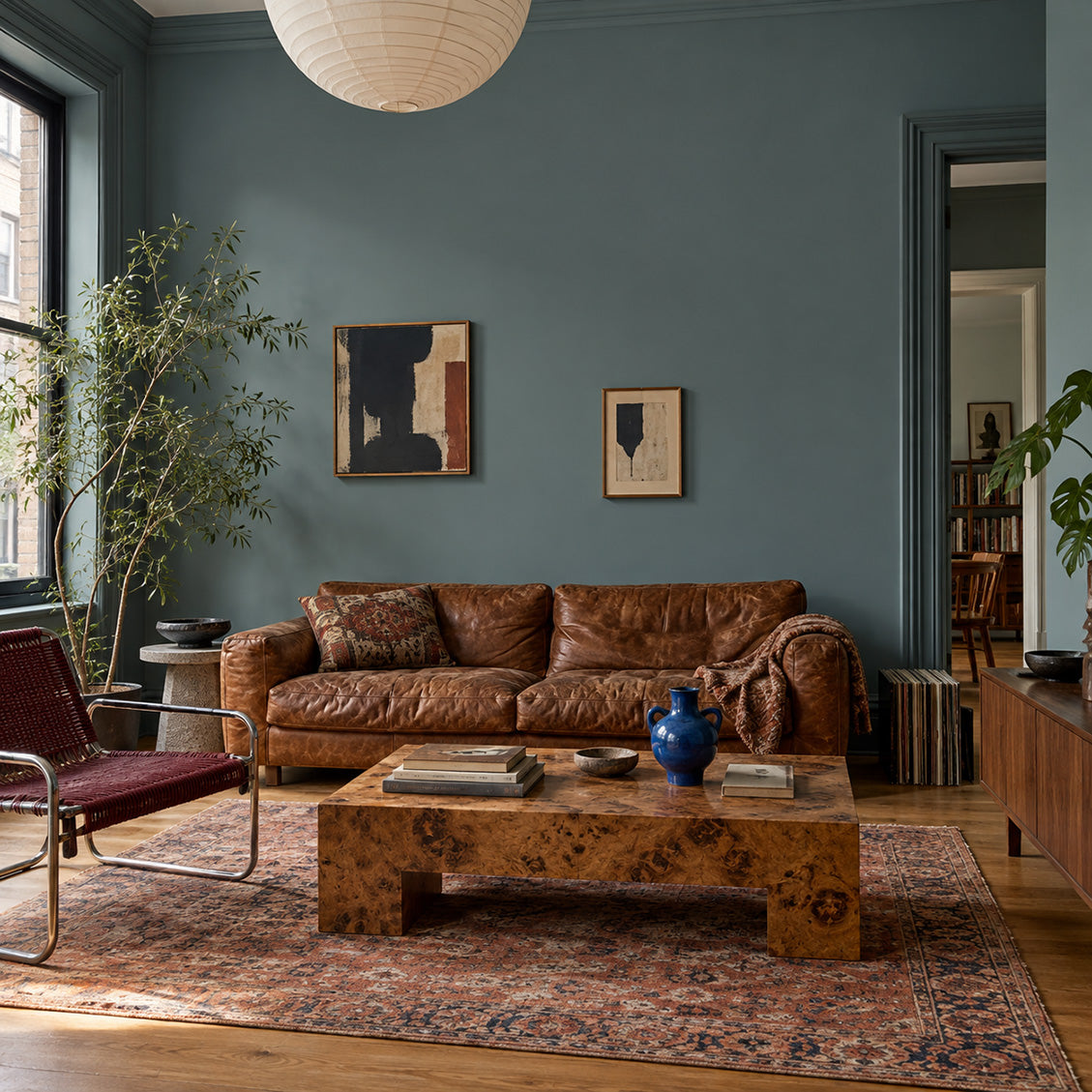 Salt Fjord smoky blue-green grey walls paired with a cognac leather sofa, burlwood table, and vintage rug.