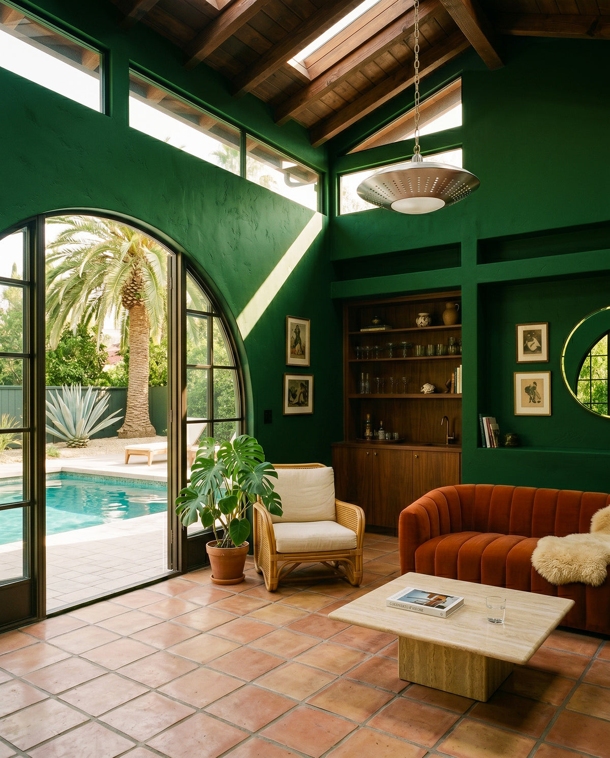 Atelier Green dining room from Jax & Hue, with green walls, warm wood, and a brass pendant