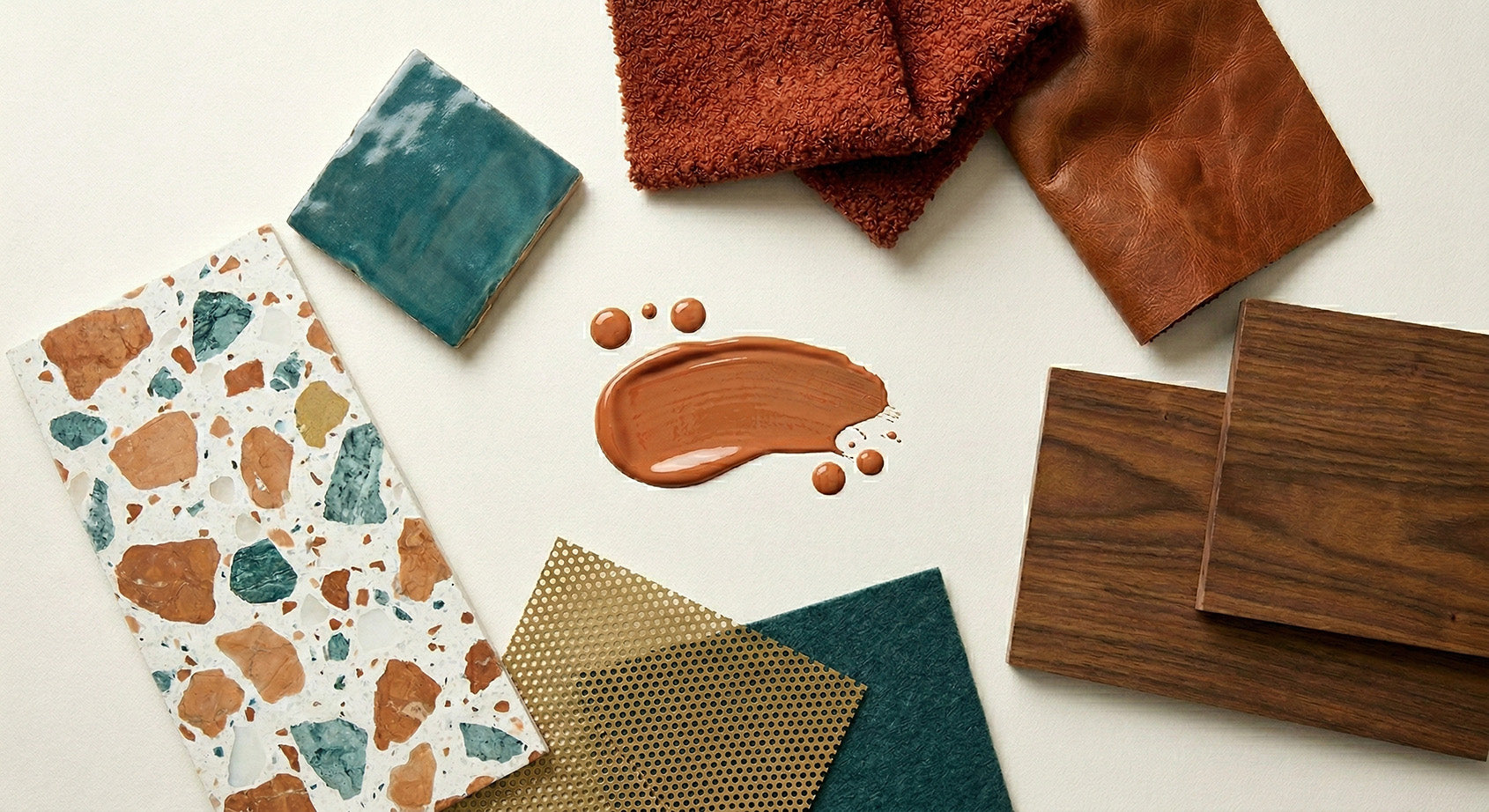 Collection of fabric swatches with different textures and colors around a terracotta paint sample